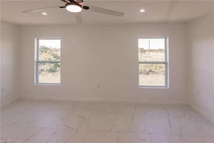Spare room with recessed lighting, light marble finish floors, and a ceiling fan
