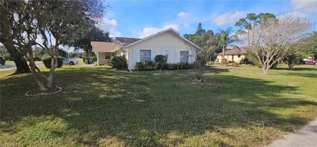 View of side of property featuring a lawn
