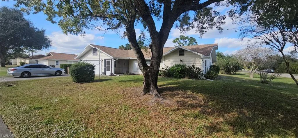 View of front facade featuring a front lawn and a garage