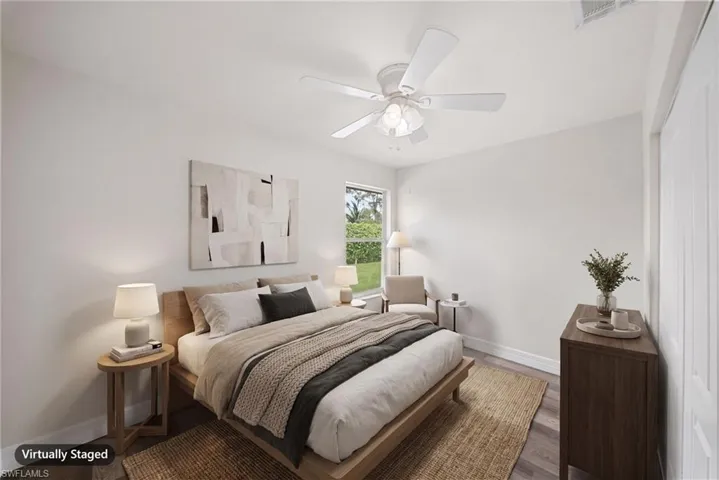 Room featuring neutral wall paint, wood-finish flooring, a ceiling fan with integrated light fixture, and double-door closet storage