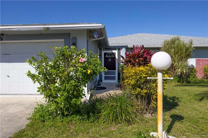 View of front of house with an attached garage, stucco siding, a front yard, and roof with shingles