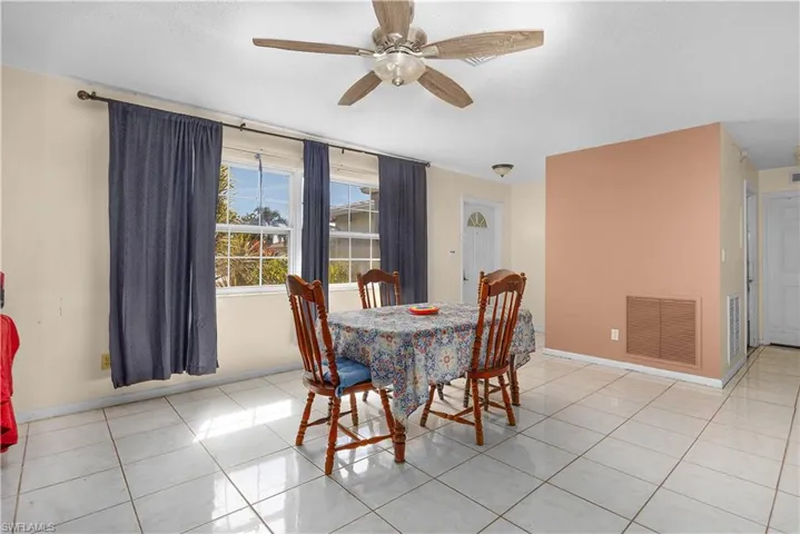 Dining space with light tile patterned floors, ceiling fan, and a textured ceiling