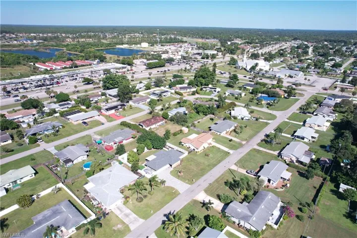 Aerial view of property and surrounding area with nearby suburban area and a large body of water