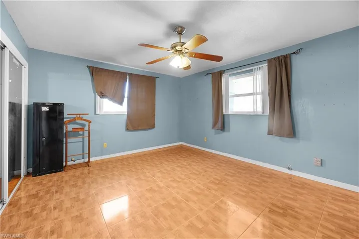 Unfurnished bedroom featuring a ceiling fan and multiple windows