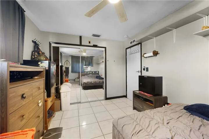 Bedroom featuring light tile patterned floors, a closet, and ceiling fan