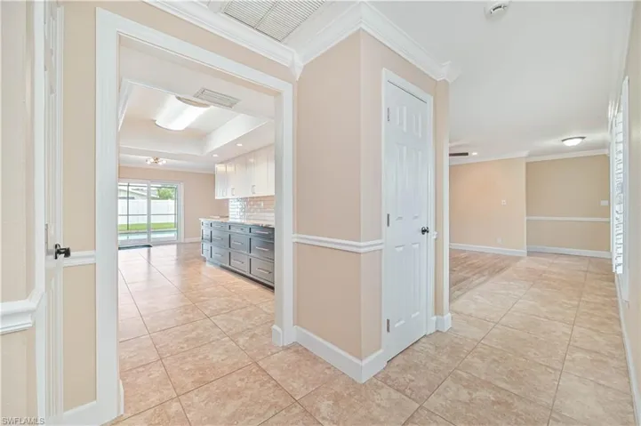 Hall featuring light tile patterned floors and ornamental molding