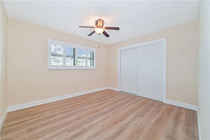 Unfurnished bedroom featuring light wood-style flooring, a closet, and a ceiling fan