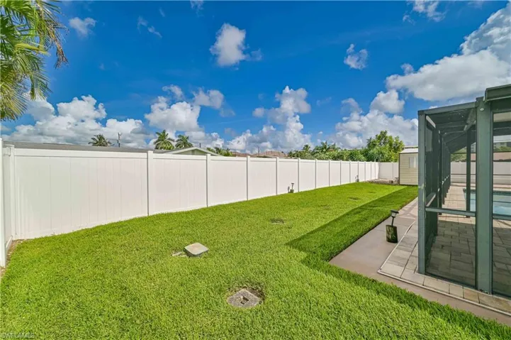 Fenced backyard with a storage unit, a patio area, and a sunroom