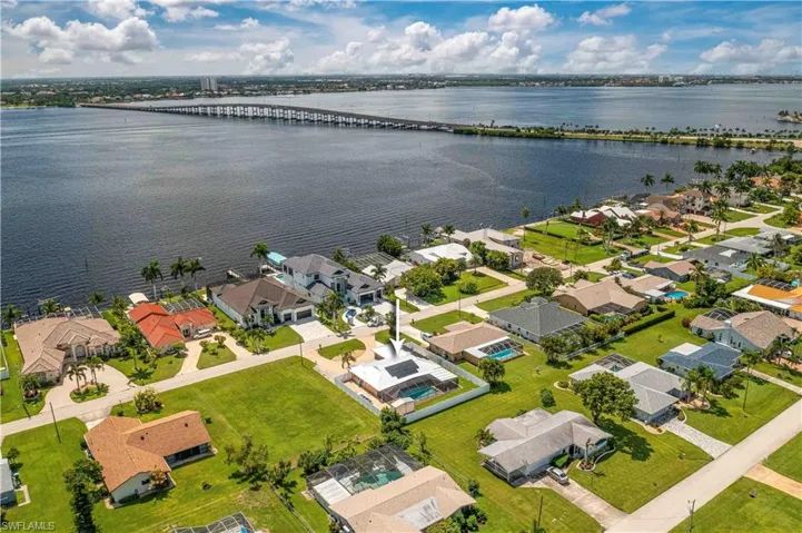 Aerial perspective of suburban area with a nearby body of water and a notable bridge