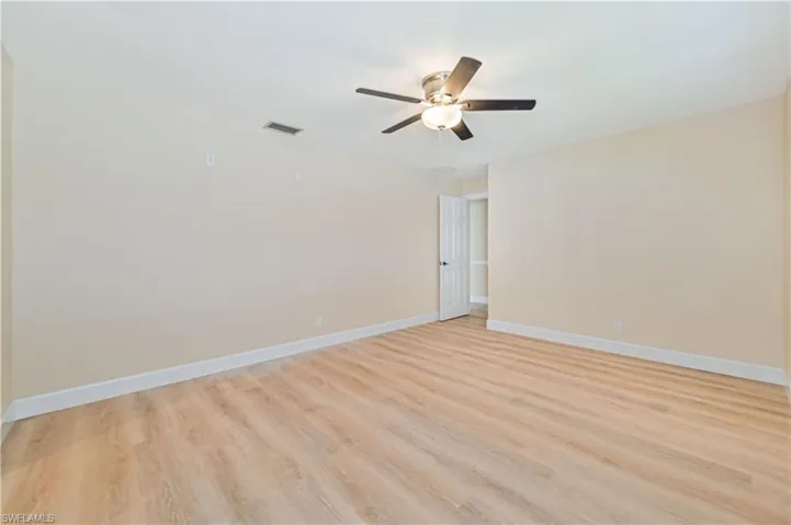 Empty room featuring light wood-type flooring and ceiling fan