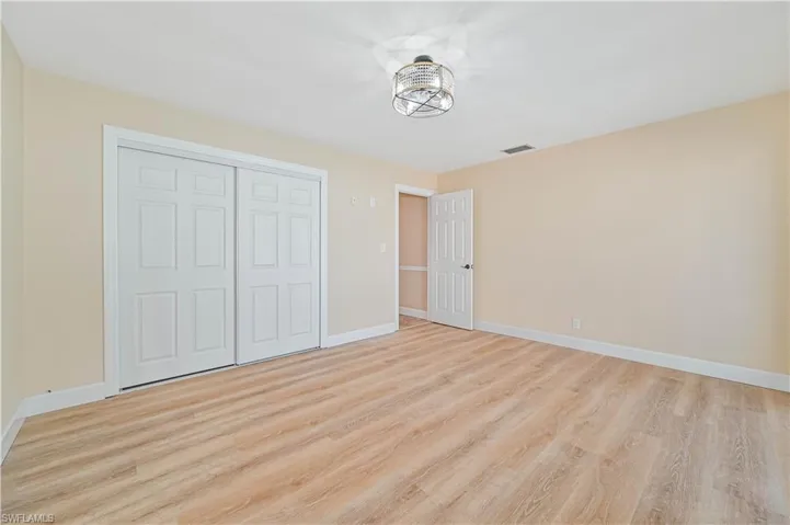 Unfurnished bedroom with light wood-type flooring and a closet
