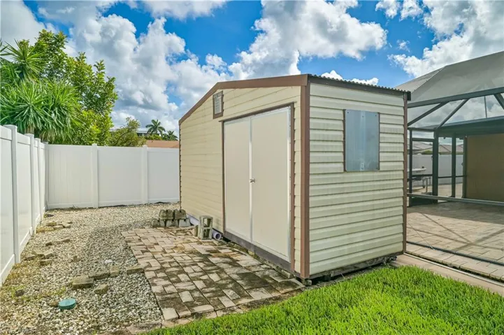 View of shed with a sunroom and a fenced backyard