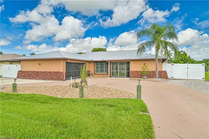 Ranch-style house featuring a gate, concrete driveway, and stucco siding