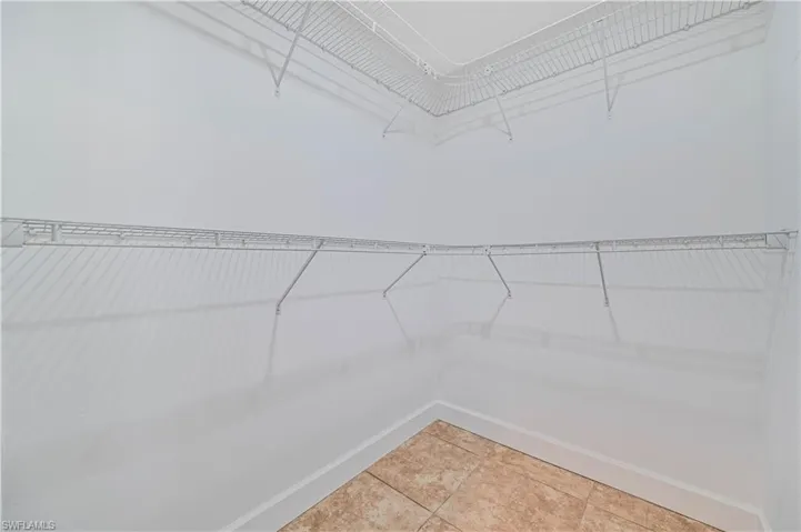Walk in closet with light tile patterned floors