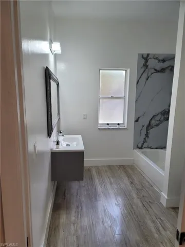 Bathroom featuring double vanity and light wood-type flooring