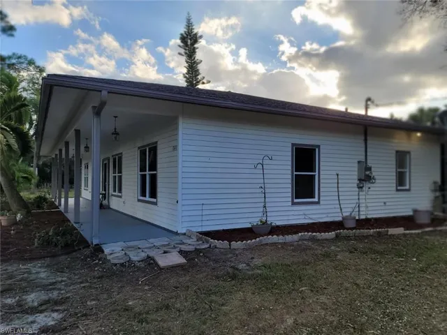 View of side of property with a shingled roof