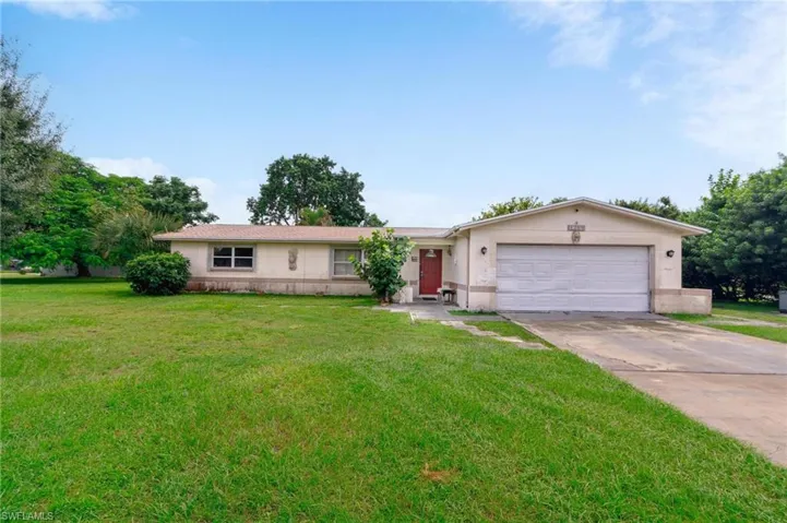 Ranch-style house featuring a garage and a front yard