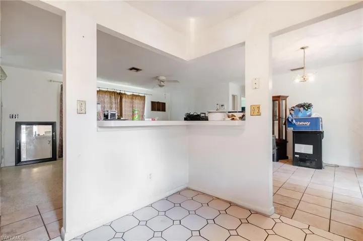 Kitchen with kitchen peninsula, ceiling fan with notable chandelier, and tile patterned floors