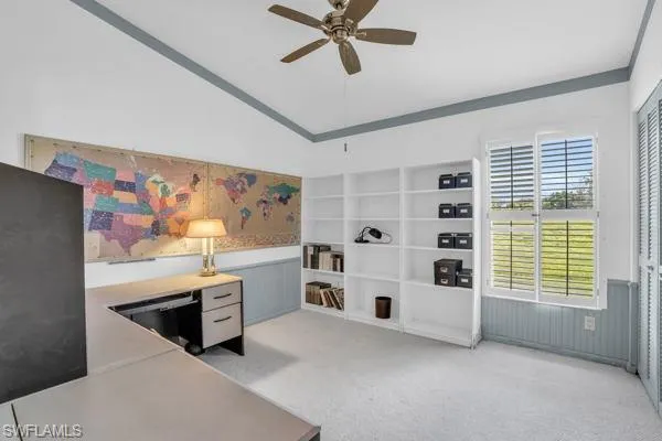 Carpeted office featuring lofted ceiling, ornamental molding, and ceiling fan