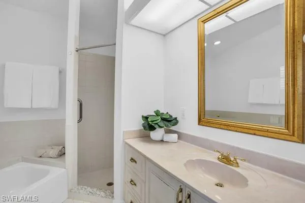 Bathroom featuring vanity and shower with separate bathtub