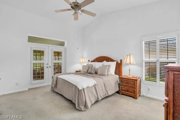 Bedroom featuring lofted ceiling, french doors, light colored carpet, and ceiling fan