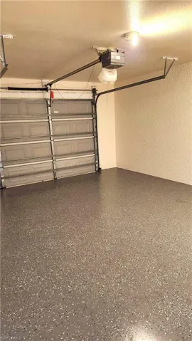 Garage with a textured wall and a garage door opener