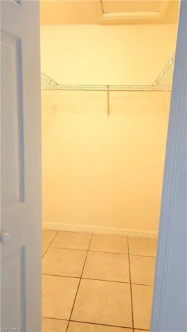 Walk in closet with light tile patterned floors