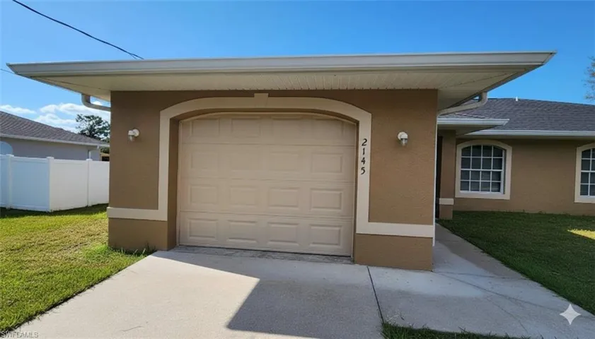 Garage featuring concrete driveway