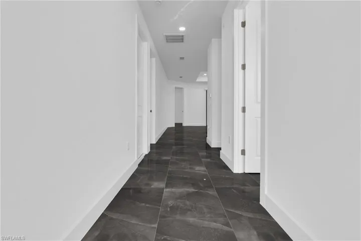 Hall with baseboards and recessed lighting