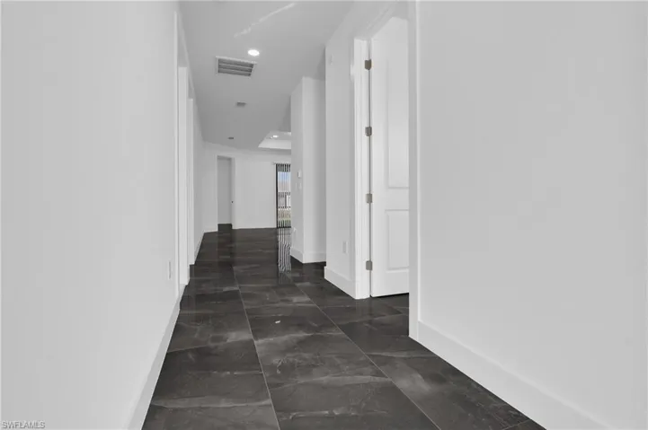 Hallway with baseboards and recessed lighting