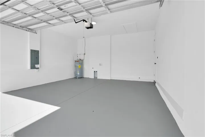 Garage featuring electric panel and electric water heater