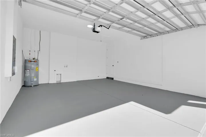 Garage featuring electric water heater and electric panel