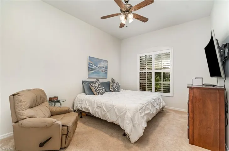Bedroom with light carpet and a ceiling fan