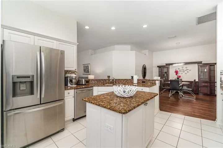 Kitchen with stainless steel appliances, white cabinetry, light tile patterned floors, a peninsula, and recessed lighting