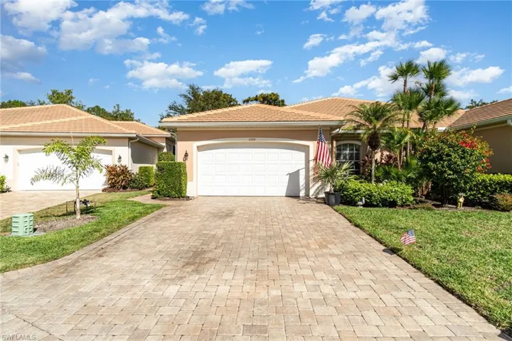 View of front of house with stucco siding, a garage, decorative driveway, and a front lawn