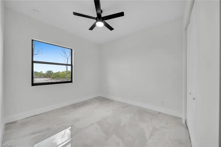 Spare room with a ceiling fan and baseboards