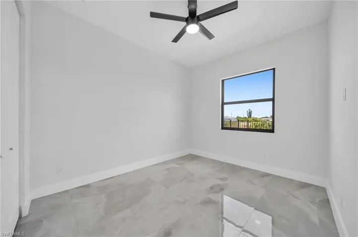 Empty room featuring baseboards and a ceiling fan