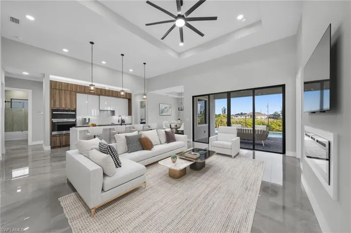 Living area featuring a ceiling fan, recessed lighting, and a high ceiling