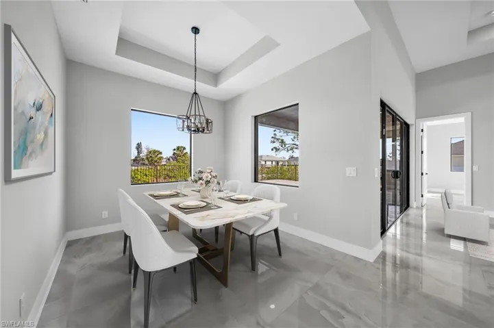 Dining room with a tray ceiling and a chandelier
