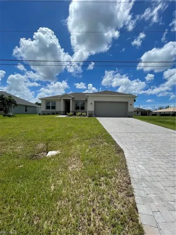 Single story home featuring a front yard and a garage