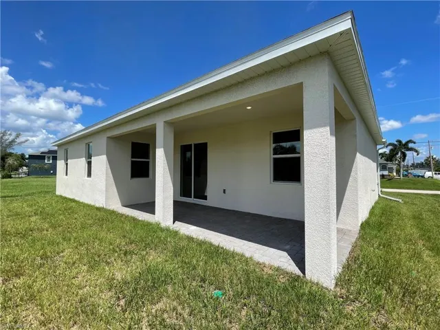 Rear view of house featuring a yard and a patio