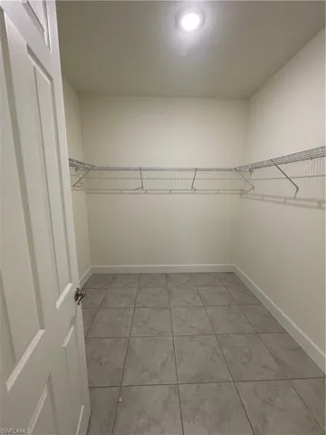 Walk in closet with light tile patterned flooring