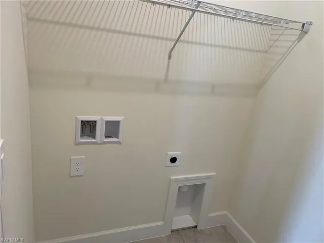 Clothes washing area with tile patterned flooring and hookup for an electric dryer