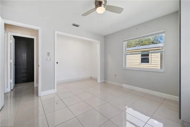 Unfurnished bedroom featuring light tile patterned floors, a closet, visible vents, ceiling fan, and baseboards