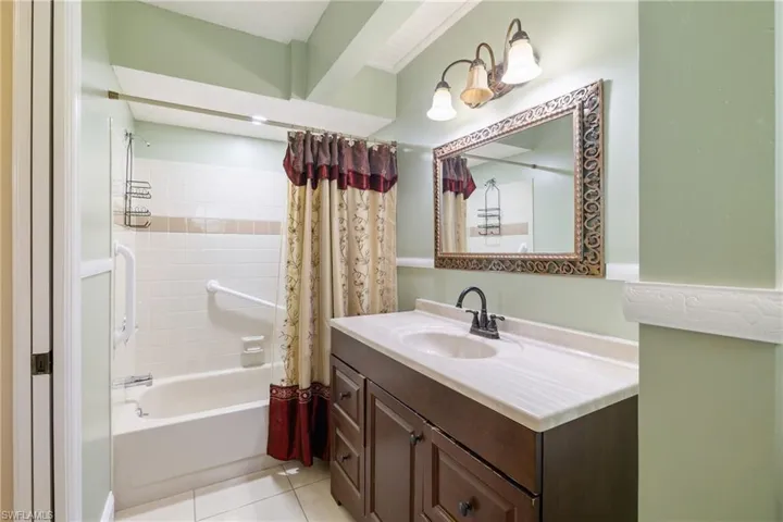 Bathroom with tile patterned flooring, vanity, and shower / tub combo