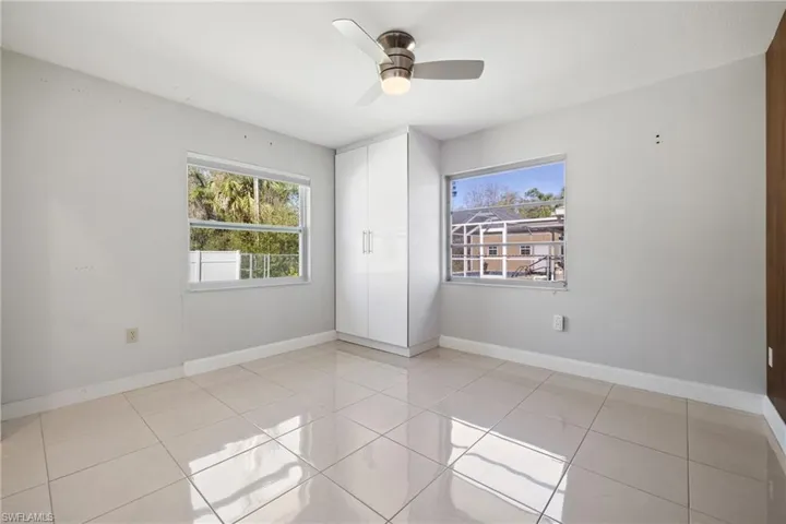 Spare room featuring ceiling fan, baseboards, and light tile patterned floors