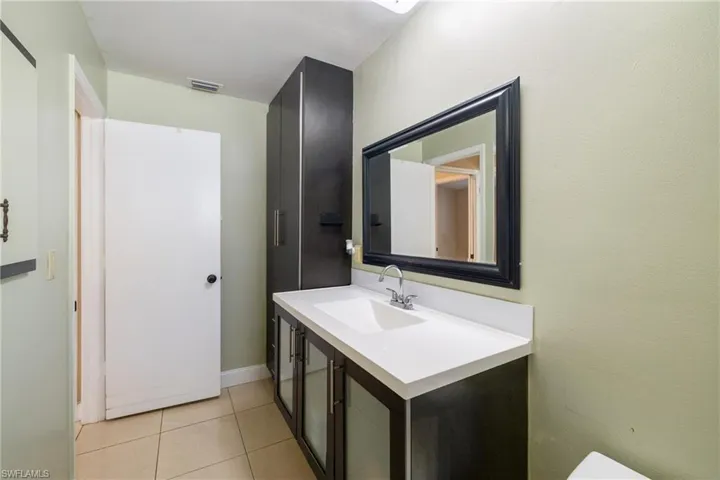 Bathroom with tile patterned floors and vanity