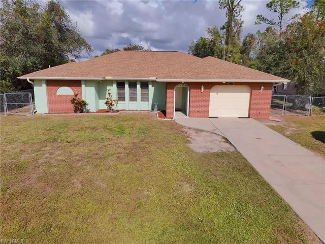 Ranch-style home with a garage and a front lawn