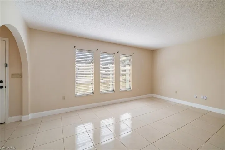 Empty room featuring light tile patterned floors and a textured ceiling