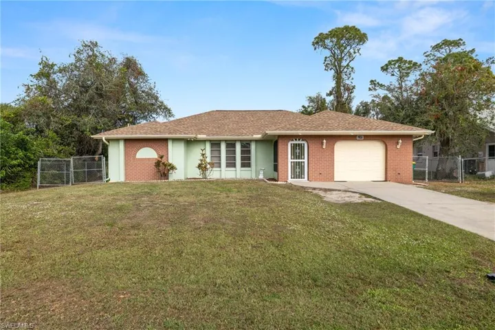 Ranch-style home with a front lawn and a garage